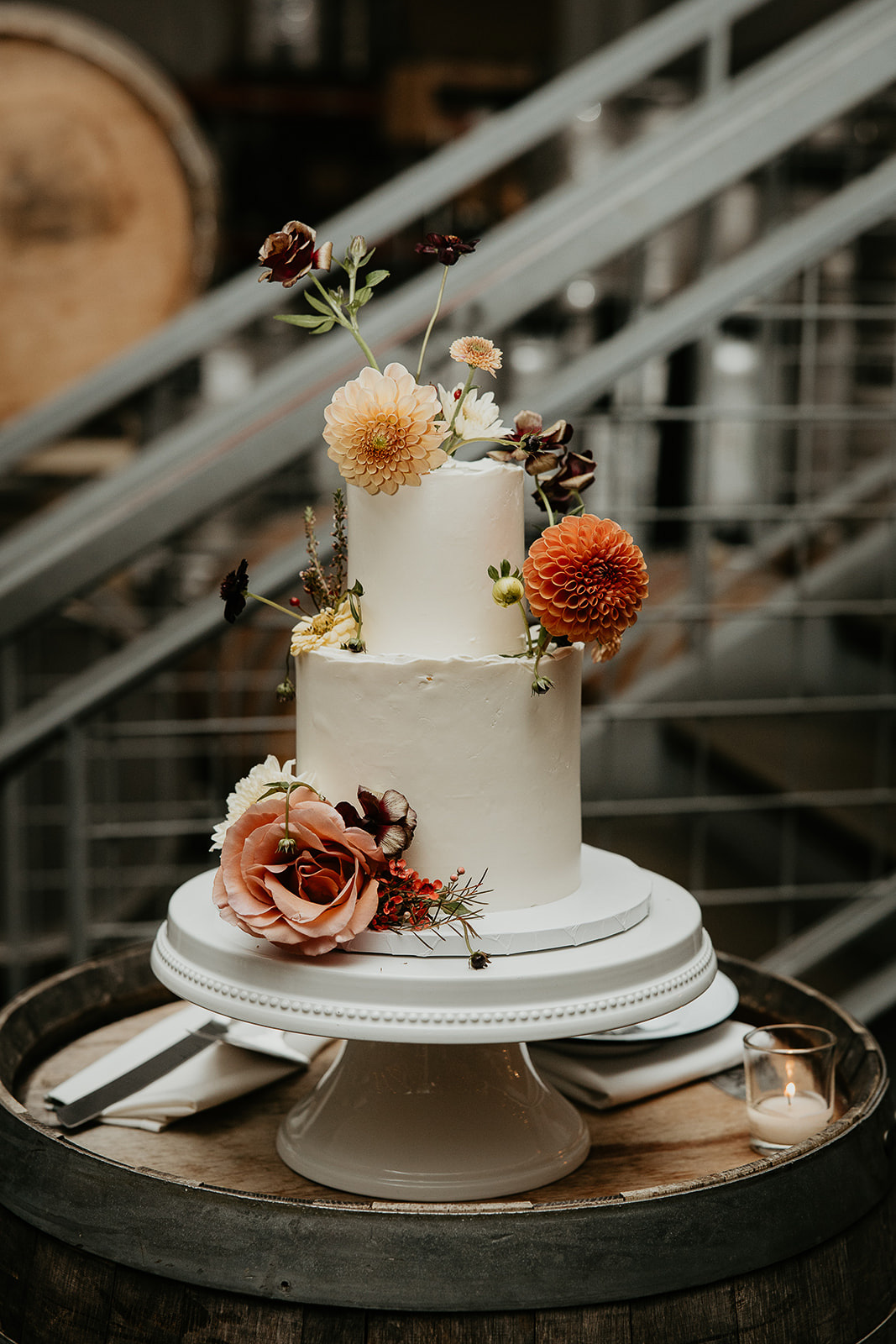 wedding cake sitting on a wine barrel.