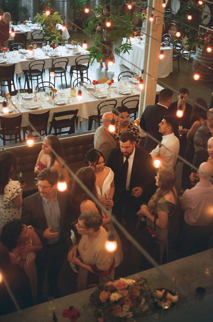 wedding guests mingling under bistro lights.