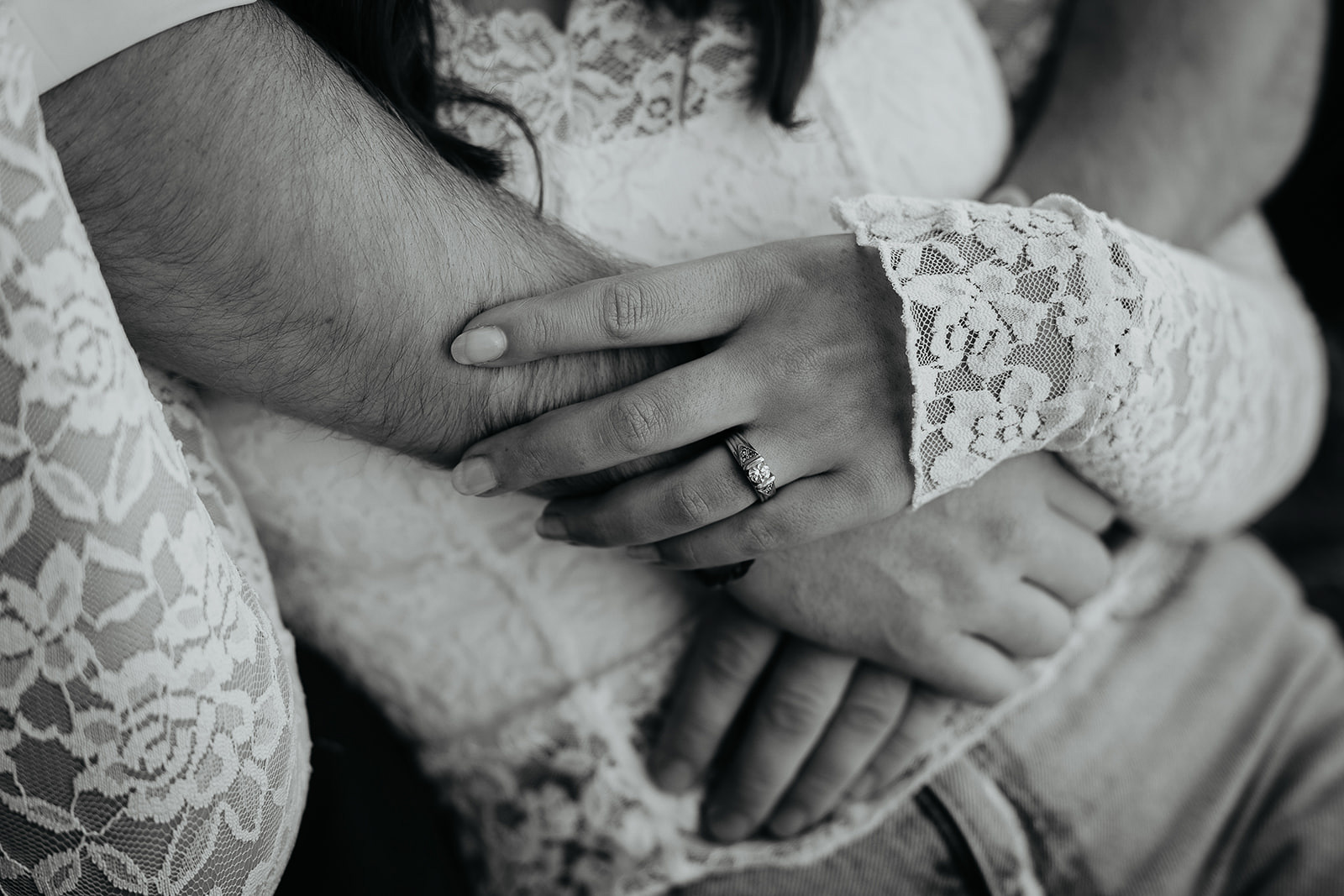 couple holding hands, the girlfriend showing off her engagement ring.