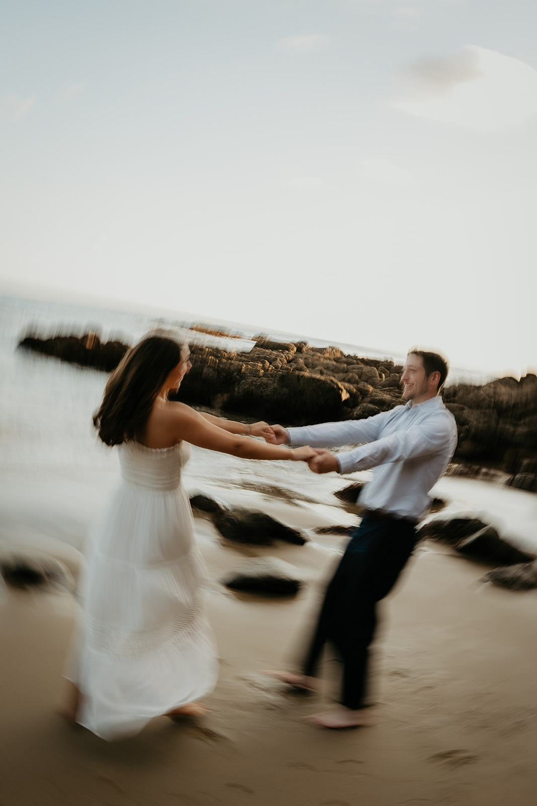couple spinning around in the sand during their Laguna Beach engagement.