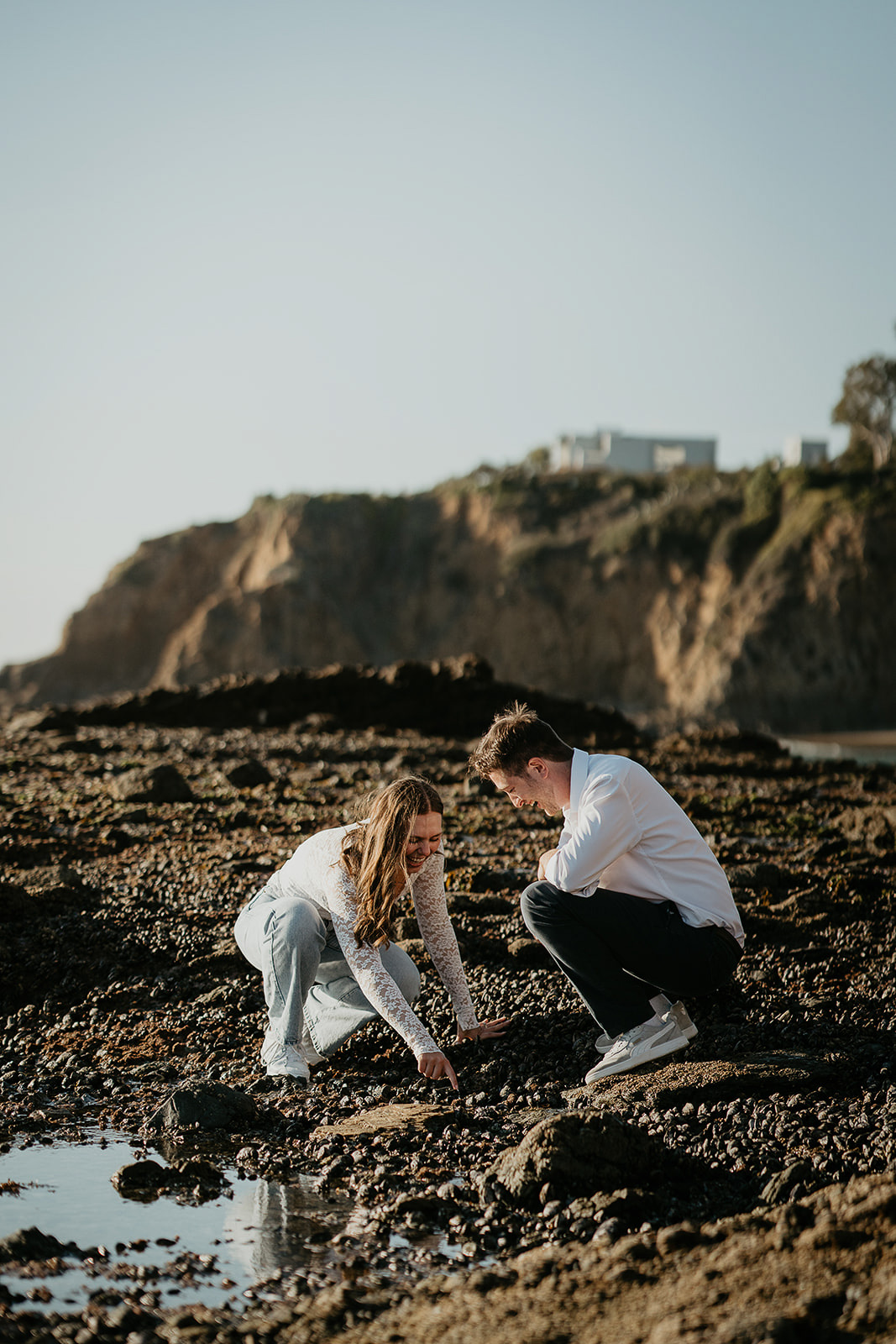 couple exploring tide pools during their Laguna Beach engagement.