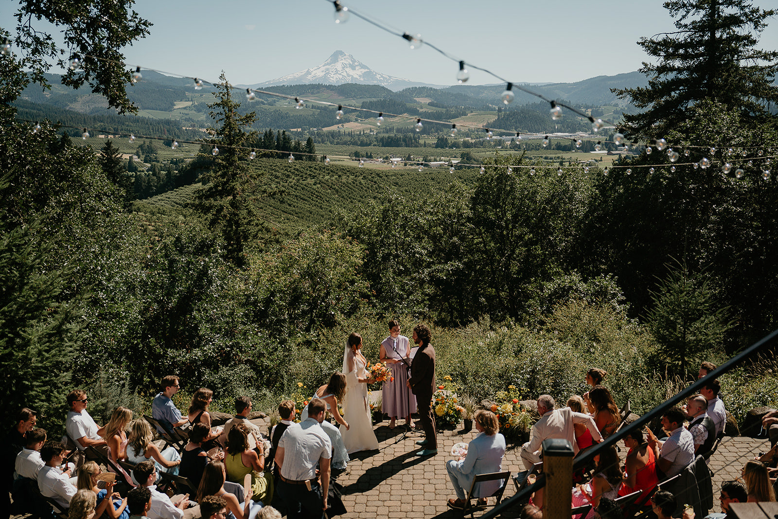 newlyweds sharing vows at crag rat hut with mount hood in the background. 