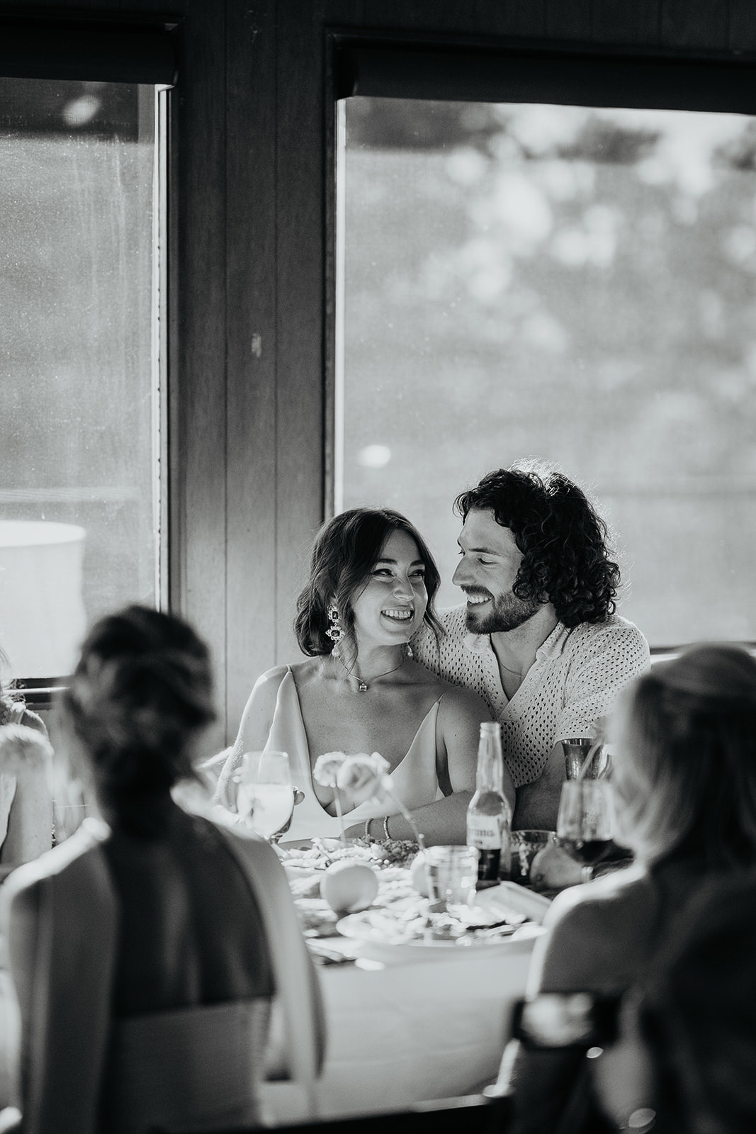 newlyweds smiling at their dinner table during their vintage inspired wedding.