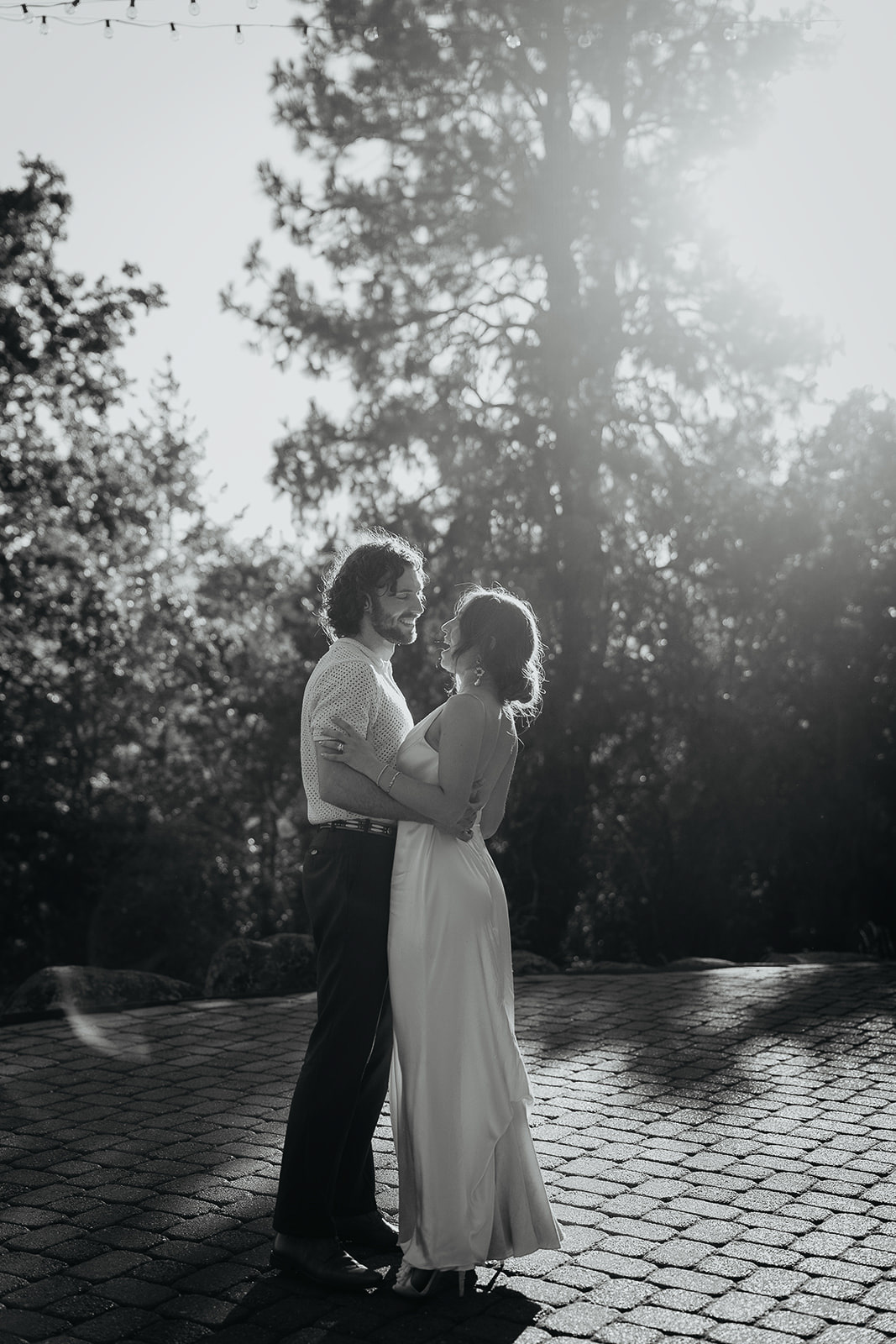 newlyweds having their first dance on a brick floor.