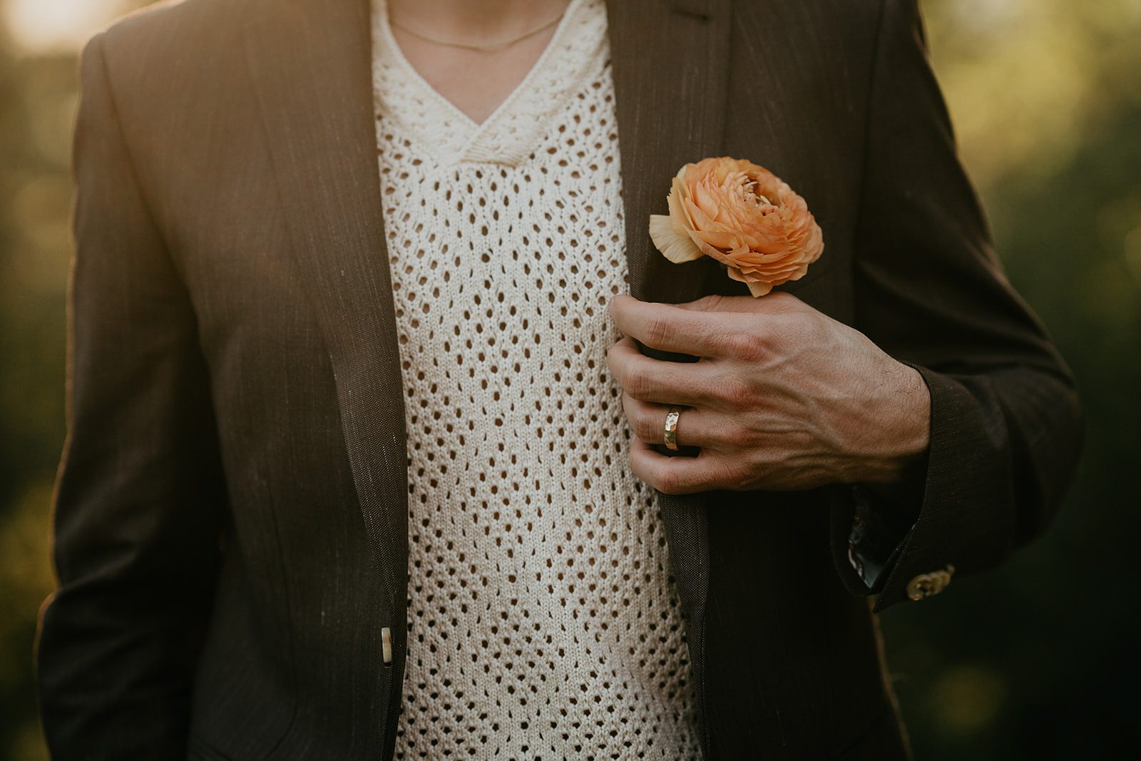 a close up of the groom's shirt, jacket, and lapel.