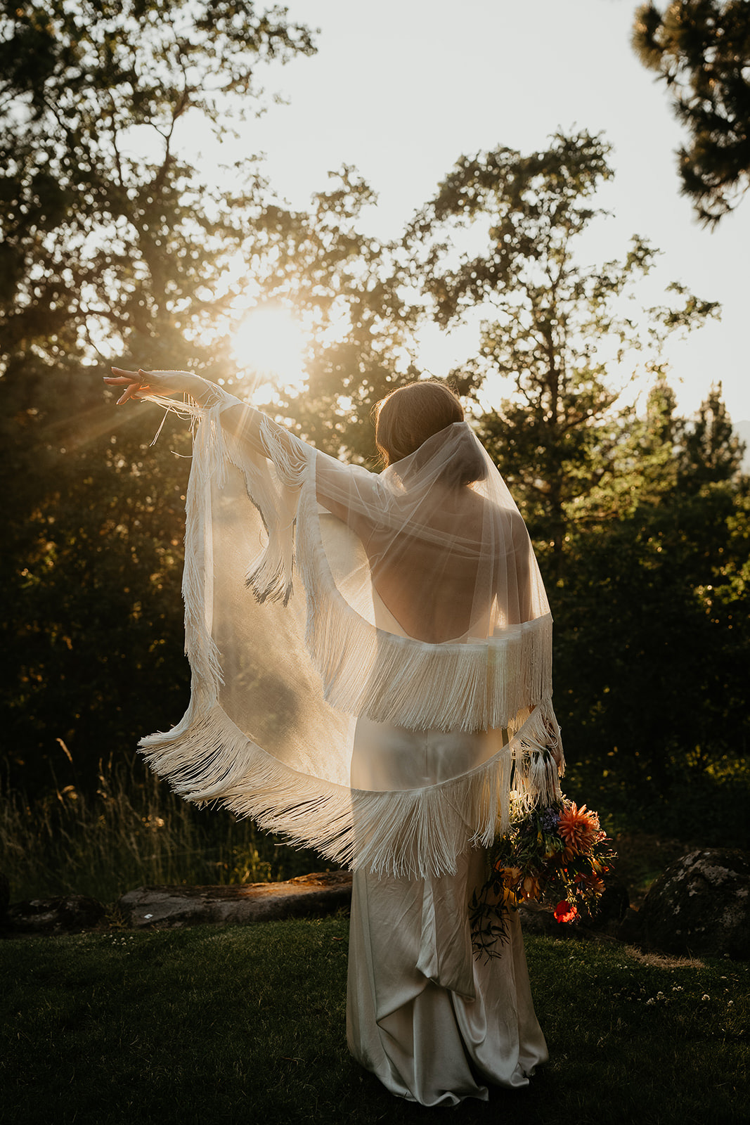 the bride showing off her veil with fringes on it during her vintage inspired wedding.