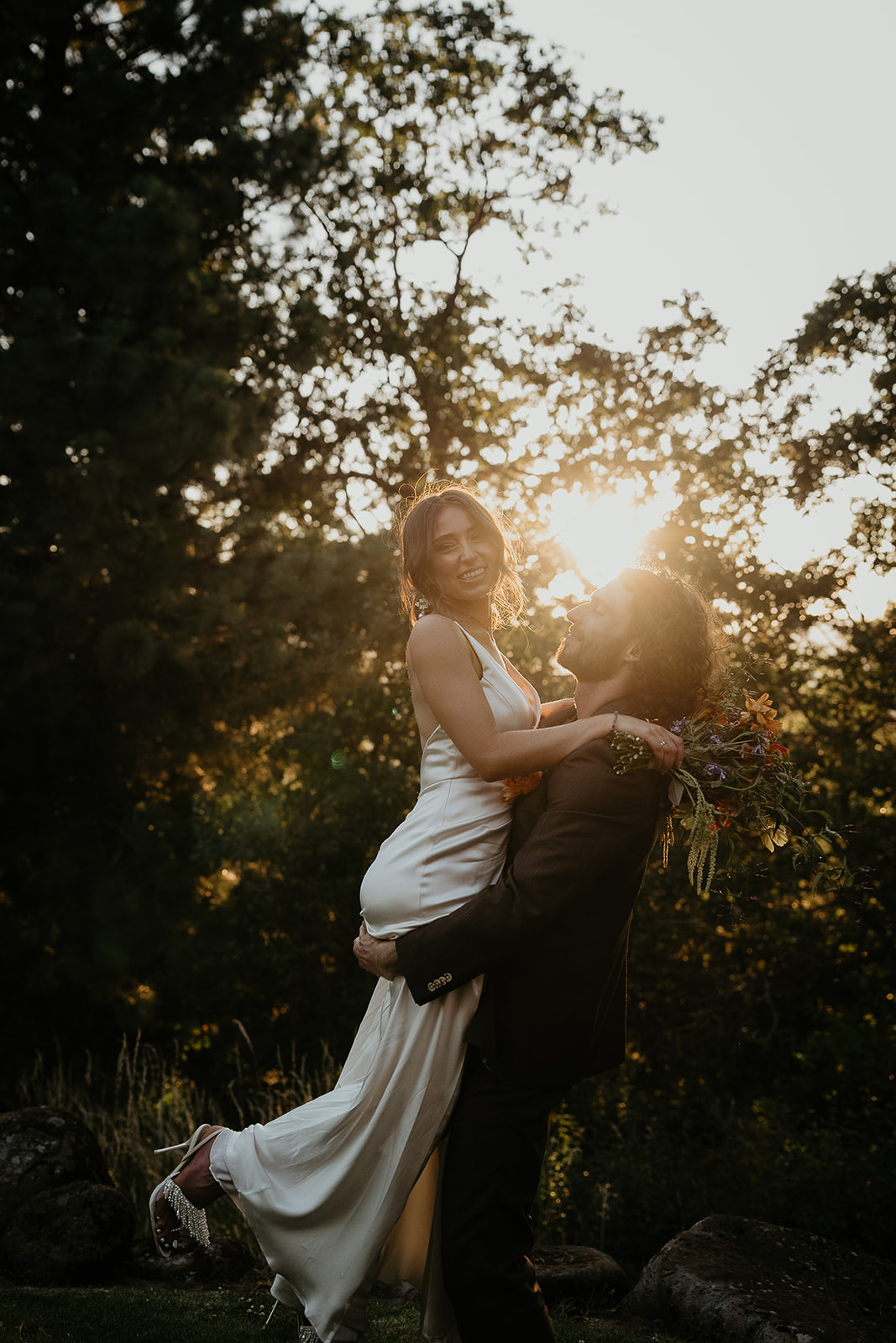 the groom picking up his bride at sunset during their vintage inspired wedding.