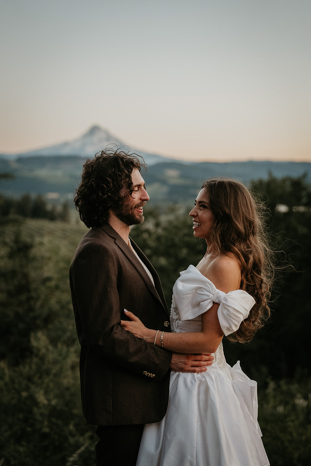 newlyweds hugging with views of mount hood behind them.