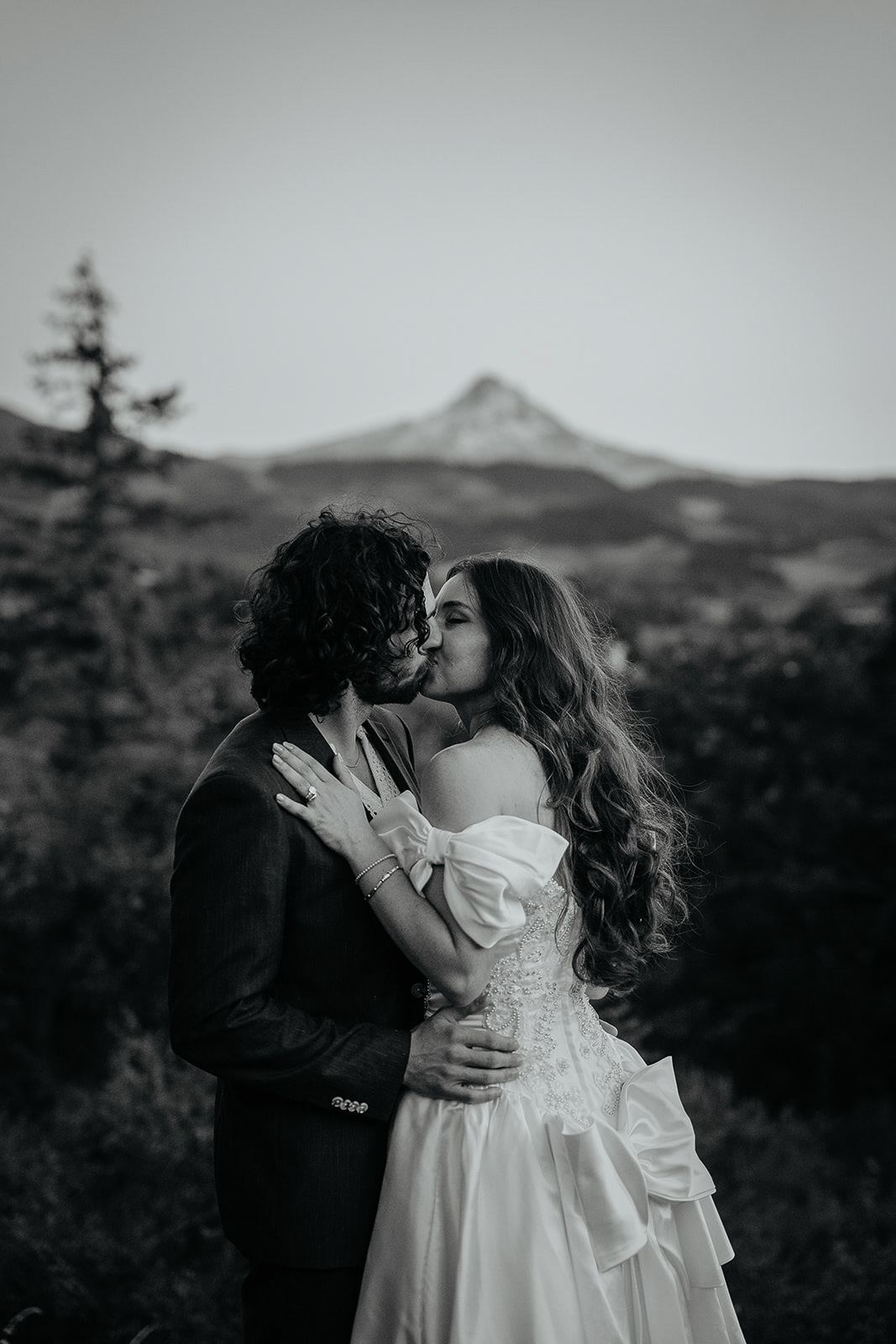 newlyweds kissing with views of mount hood behind them during their vintage inspired wedding.
