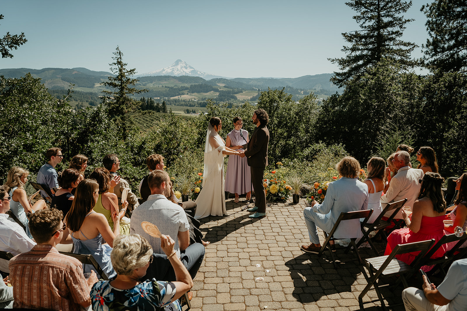 newlyweds during their wedding ceremony at crag rat hut with their guests watching on.