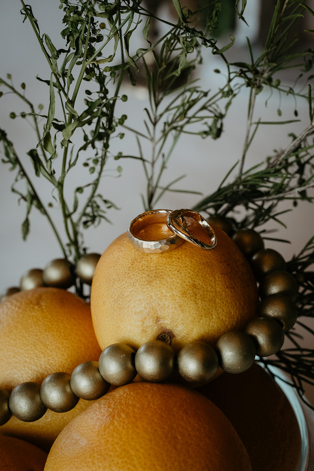 rings resting on a bowl of oranges.
