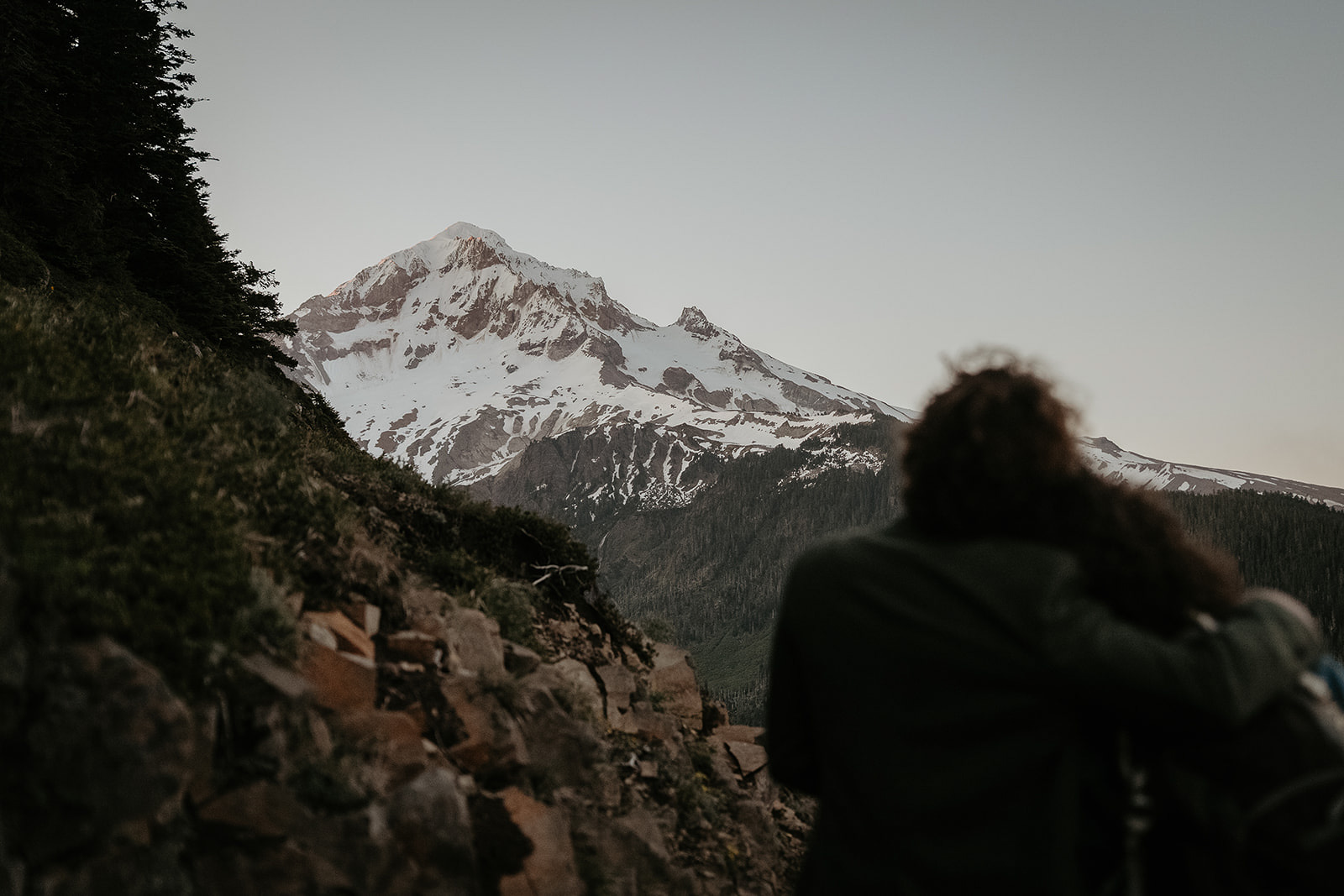 couple hugging taking in the view of mount Hood during their wedding anniversary photoshoot.