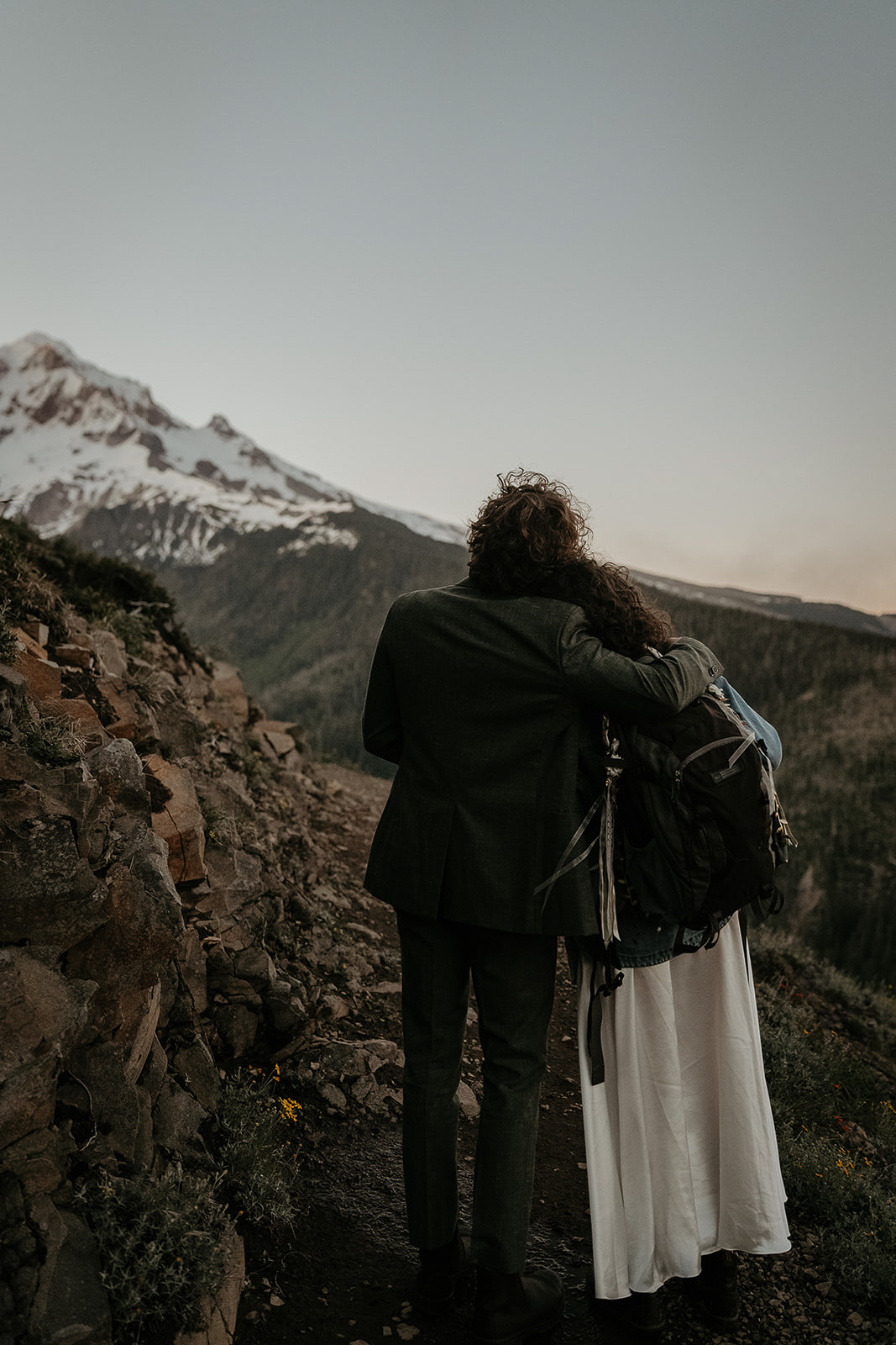couple hugging on a hiking trail in front of mount Hood.