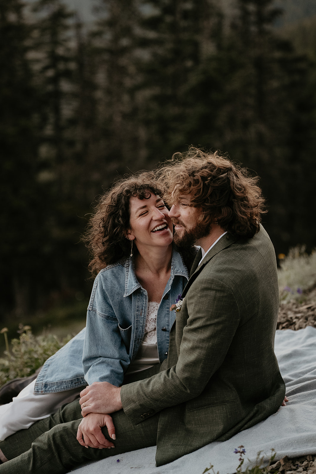 Couple enjoying a picnic in the mountains during their wedding anniversary photoshoot.