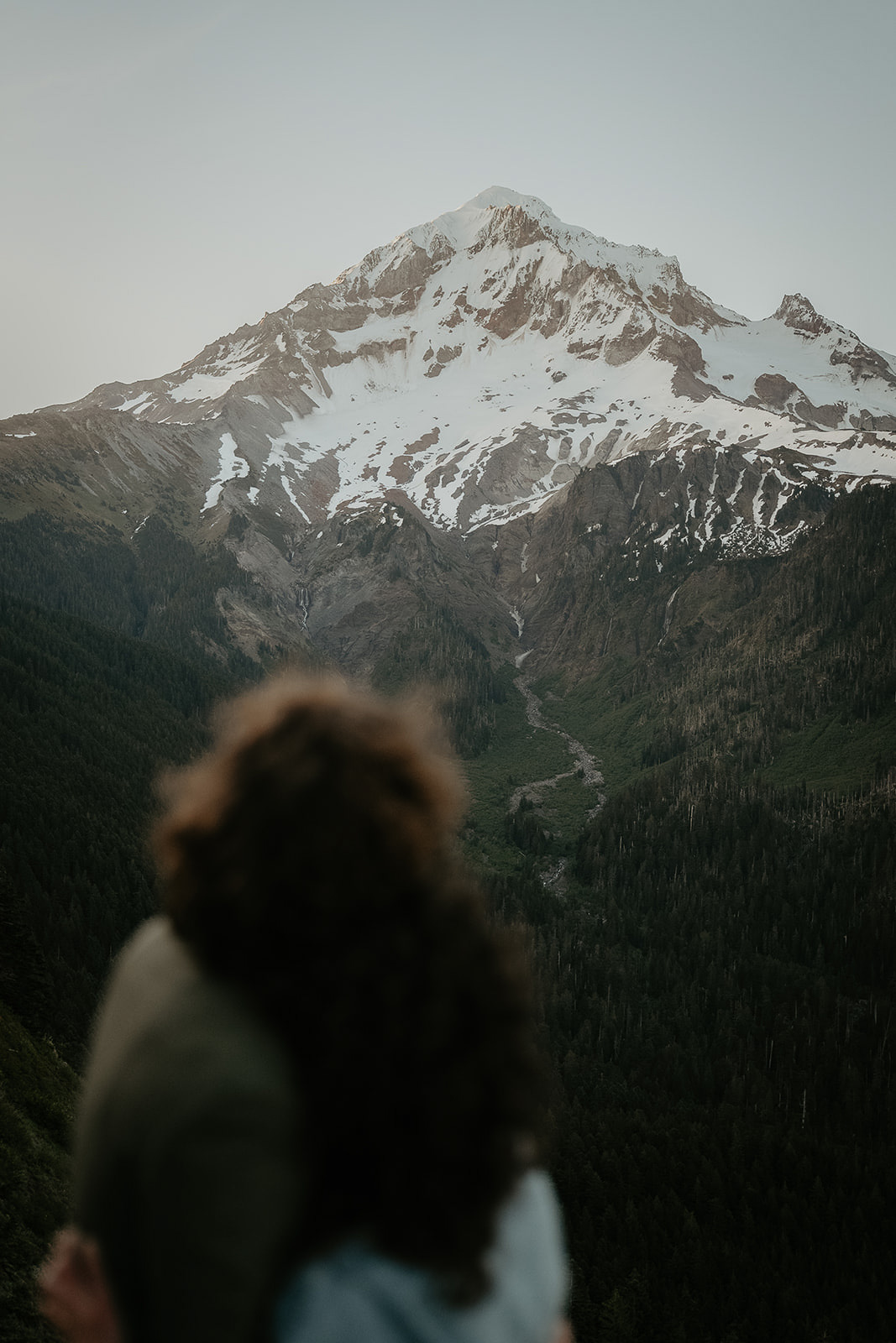 Couple hugging enjoying a view of mount Hood during their wedding anniversary photoshoot.