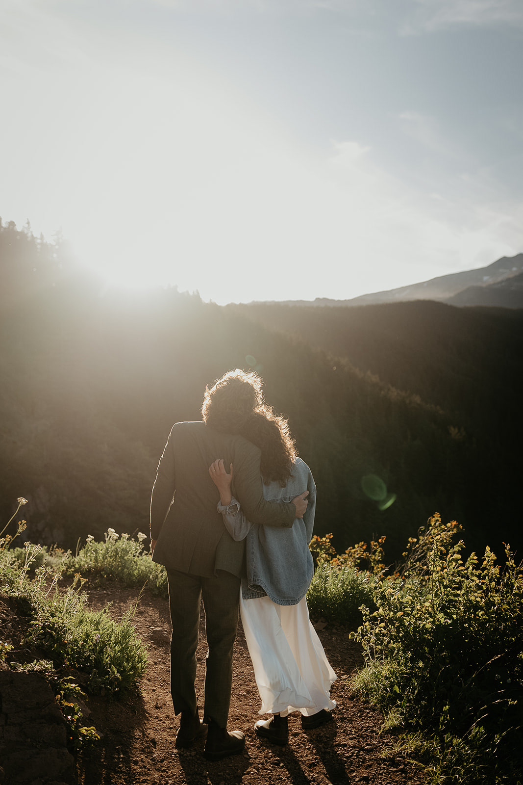 couple enjoying the sunrise in the mountains during their wedding anniversary photoshoot.