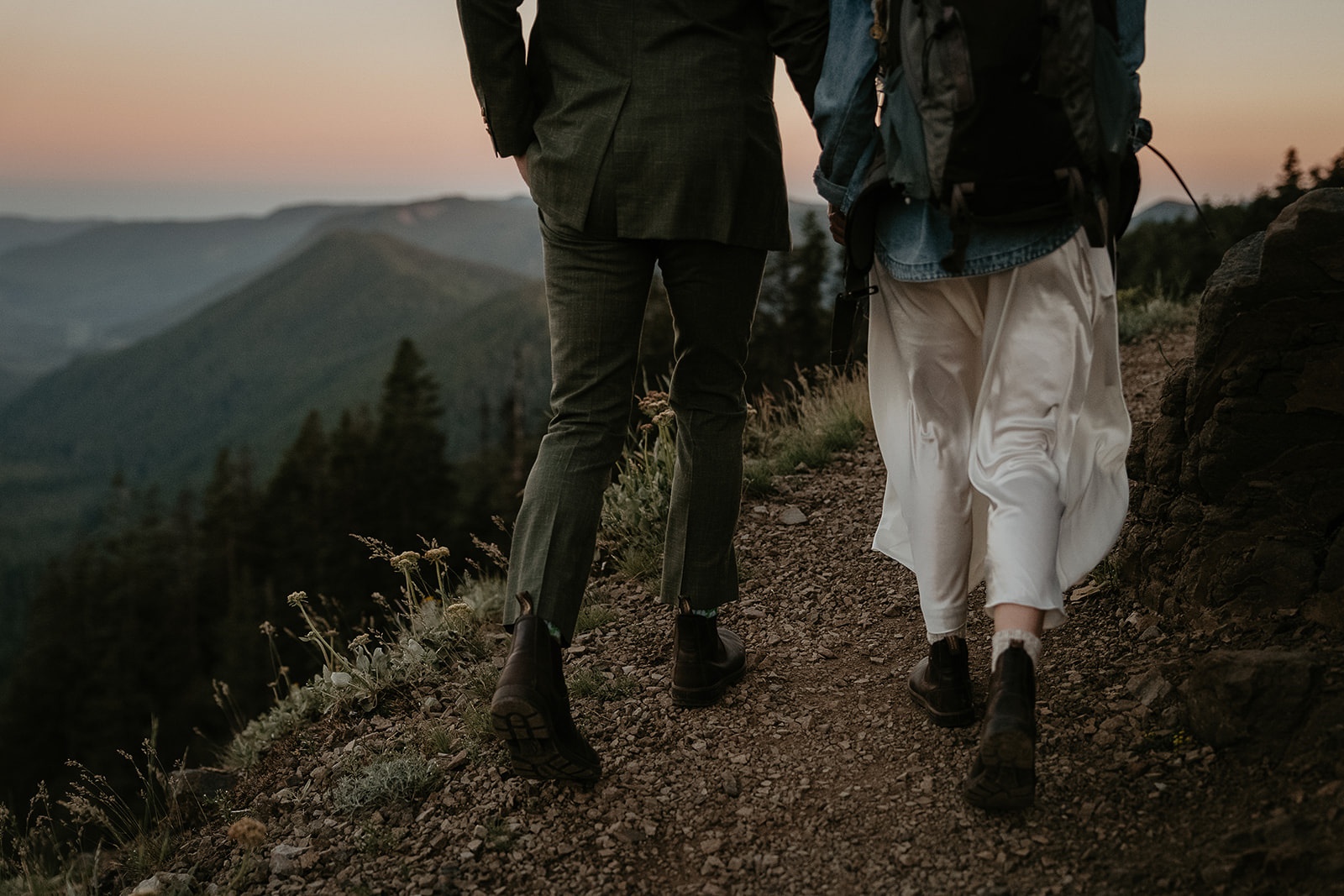 couple hiking on a dirt hiking trail in the mountains.