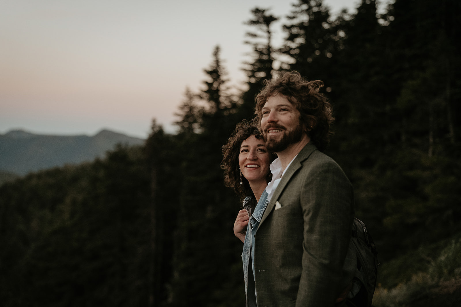 couple smiling and enjoying a mountain view.