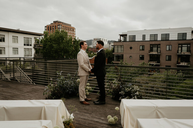 newlyweds holding hands on a rooftop for an Ecotrust wedding styled shoot.