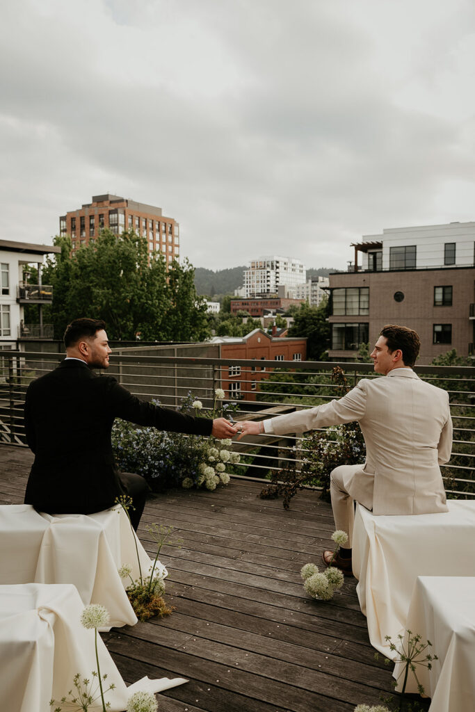 Newlyweds holding hands on a rooftop for an Ecotrust wedding styled shoot.