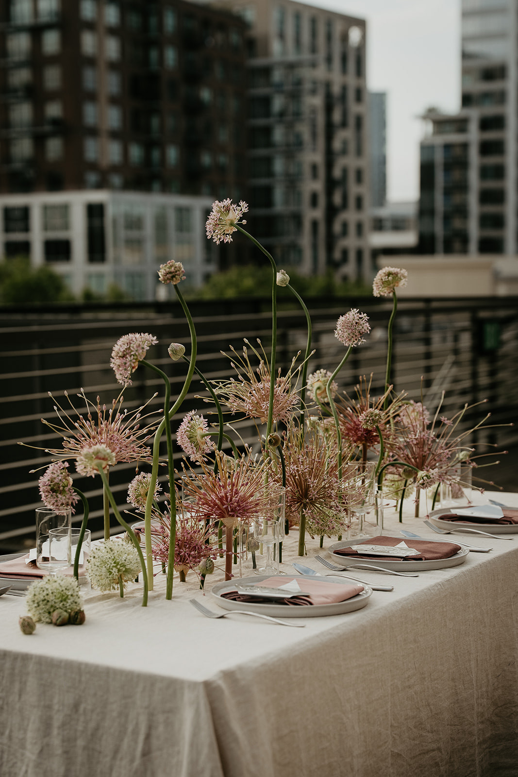 A tablescape with flowers and cutlery and the Portland skyline in the background for an Ecotrust wedding styled shoot.