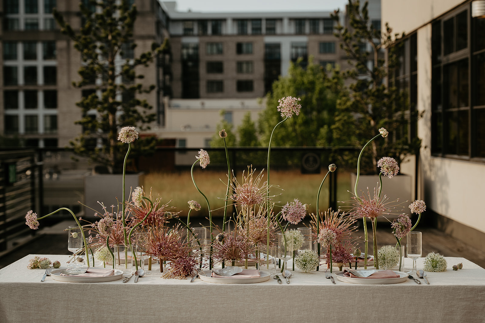 A decorated wedding table with flowers, wine glasses, plates, and cutlery.