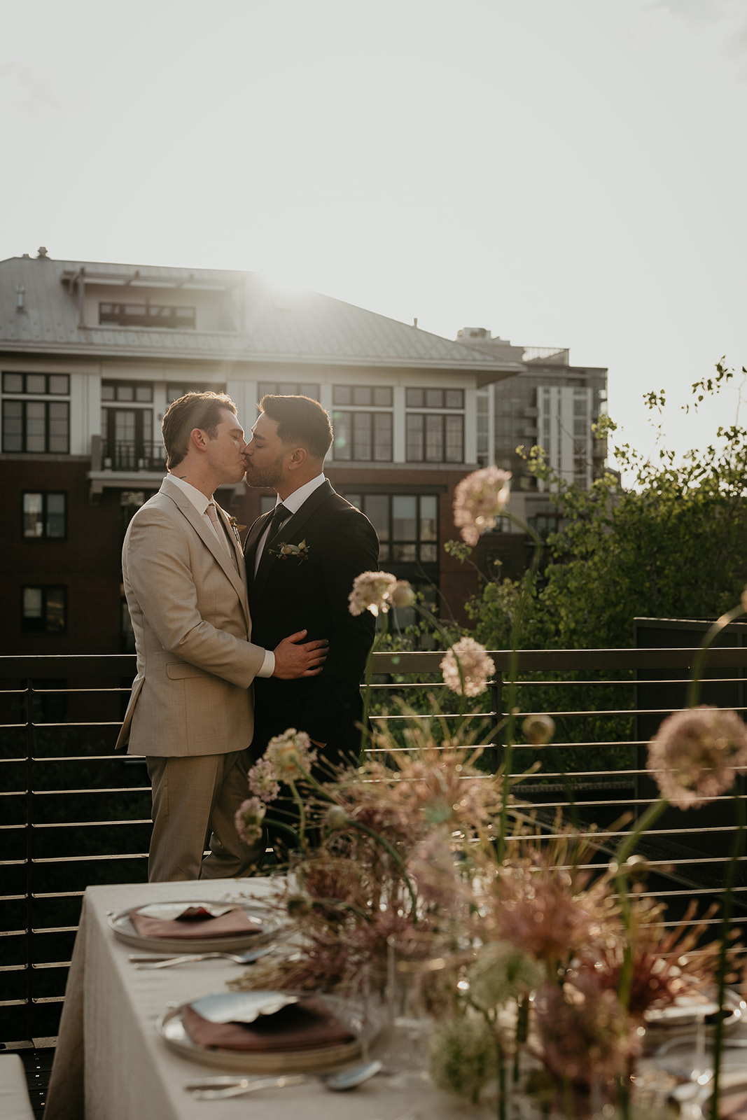 Newlyweds kissing at sunset on a rooftop for an Ecotrust wedding styled shoot.