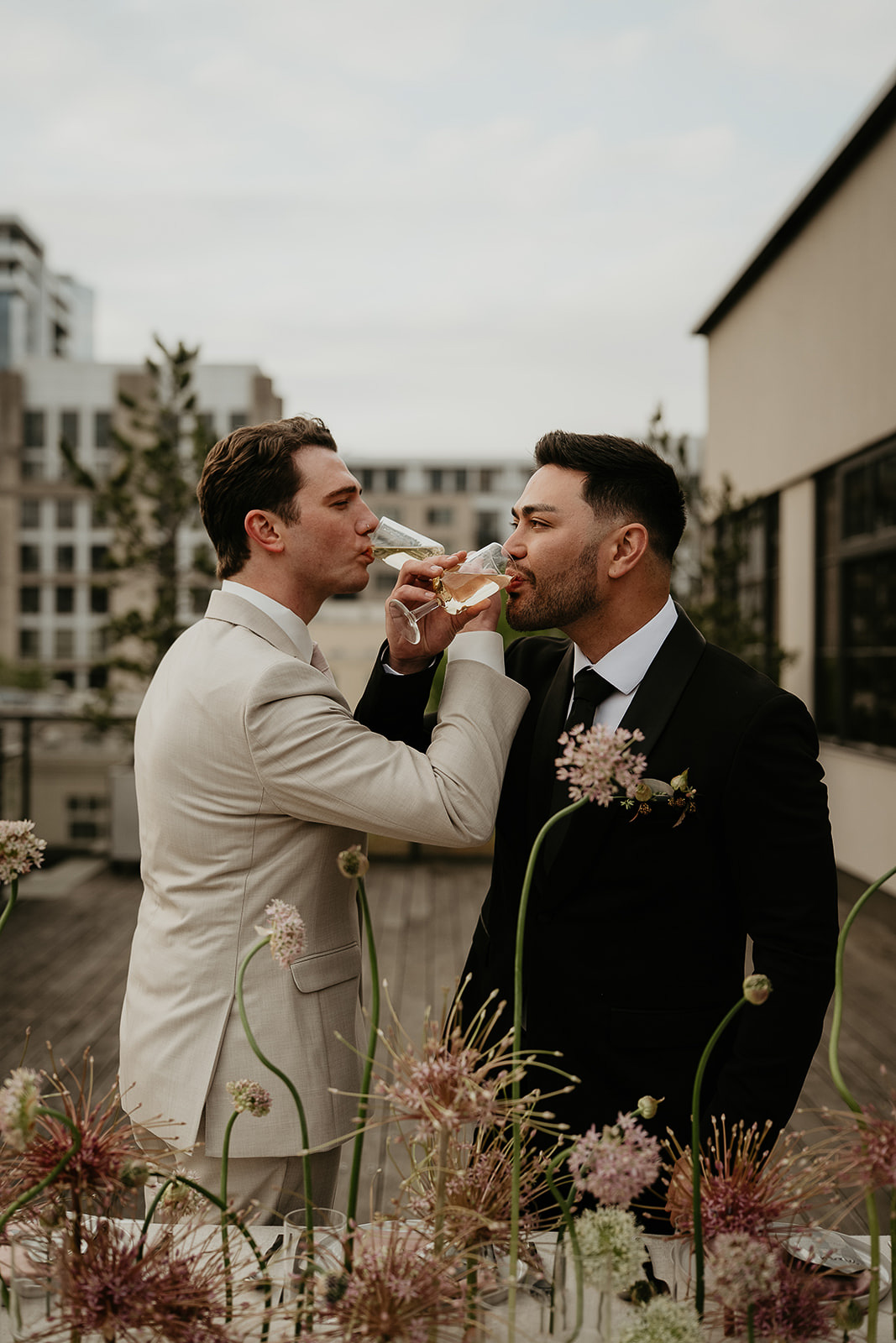 newlyweds drinking champagne on a rooftop for an Ecotrust wedding styled shoot.