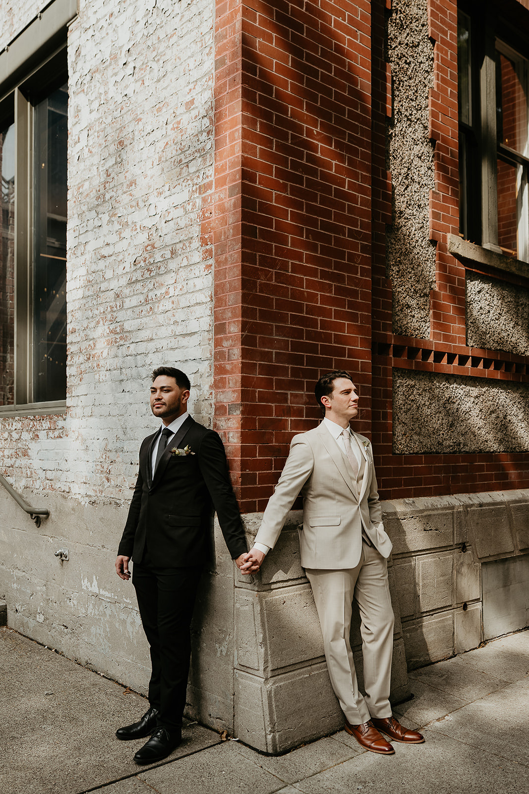 newlyweds holding hands outside the brick ecotrust building.