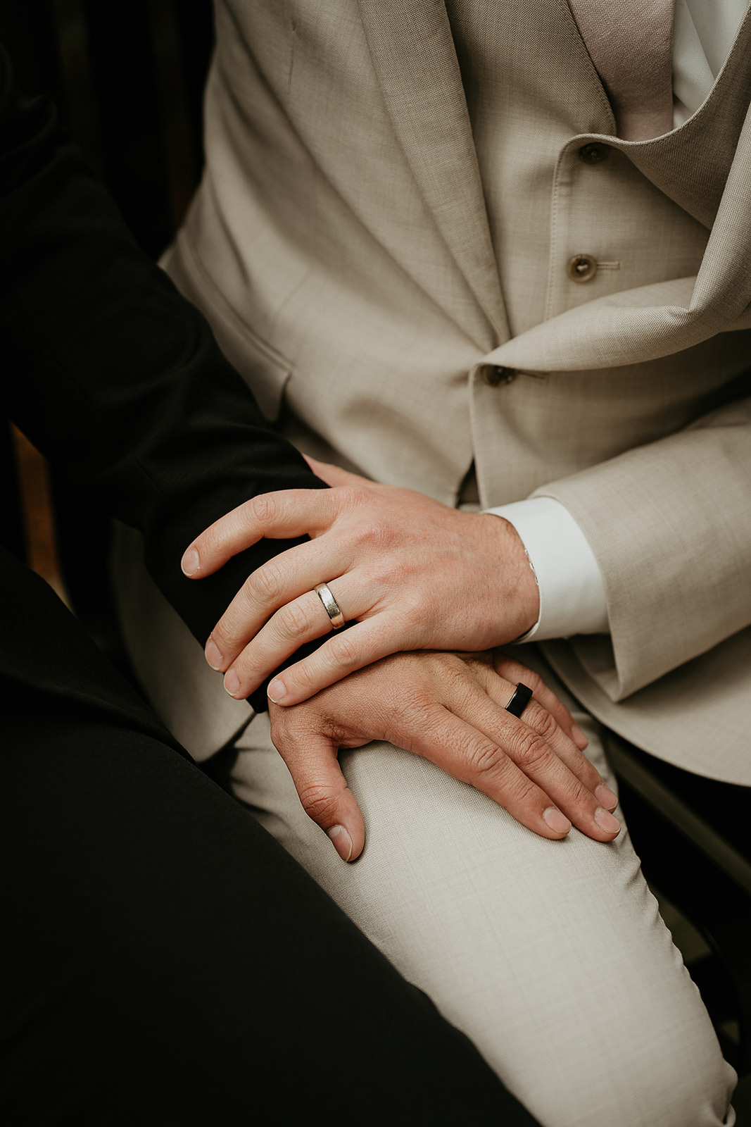 newlyweds holding hands, one of them with his hand on the other's thigh.