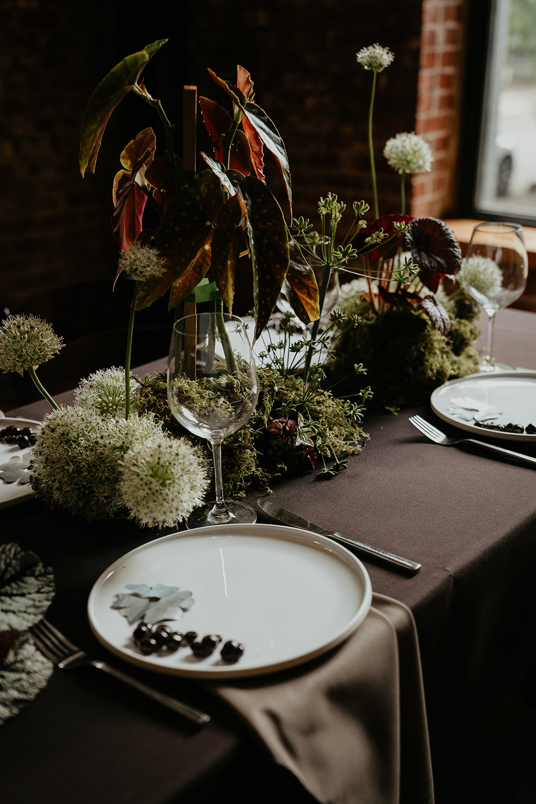 A tablescape filled with flowers, plants, and tablewear for an Ecotrust wedding styled shoot.