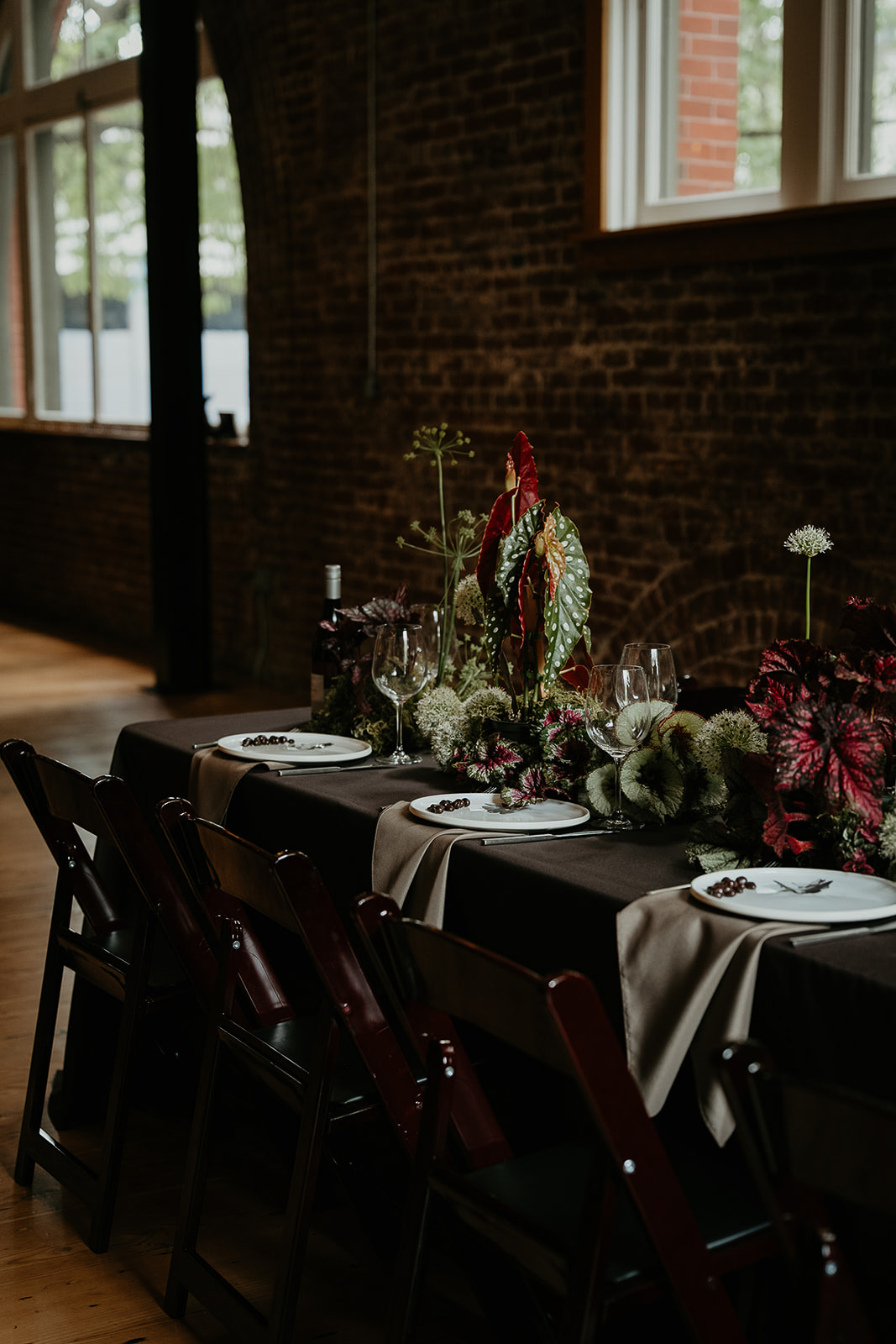 An elaborate tablescape inside a brick-walled building.