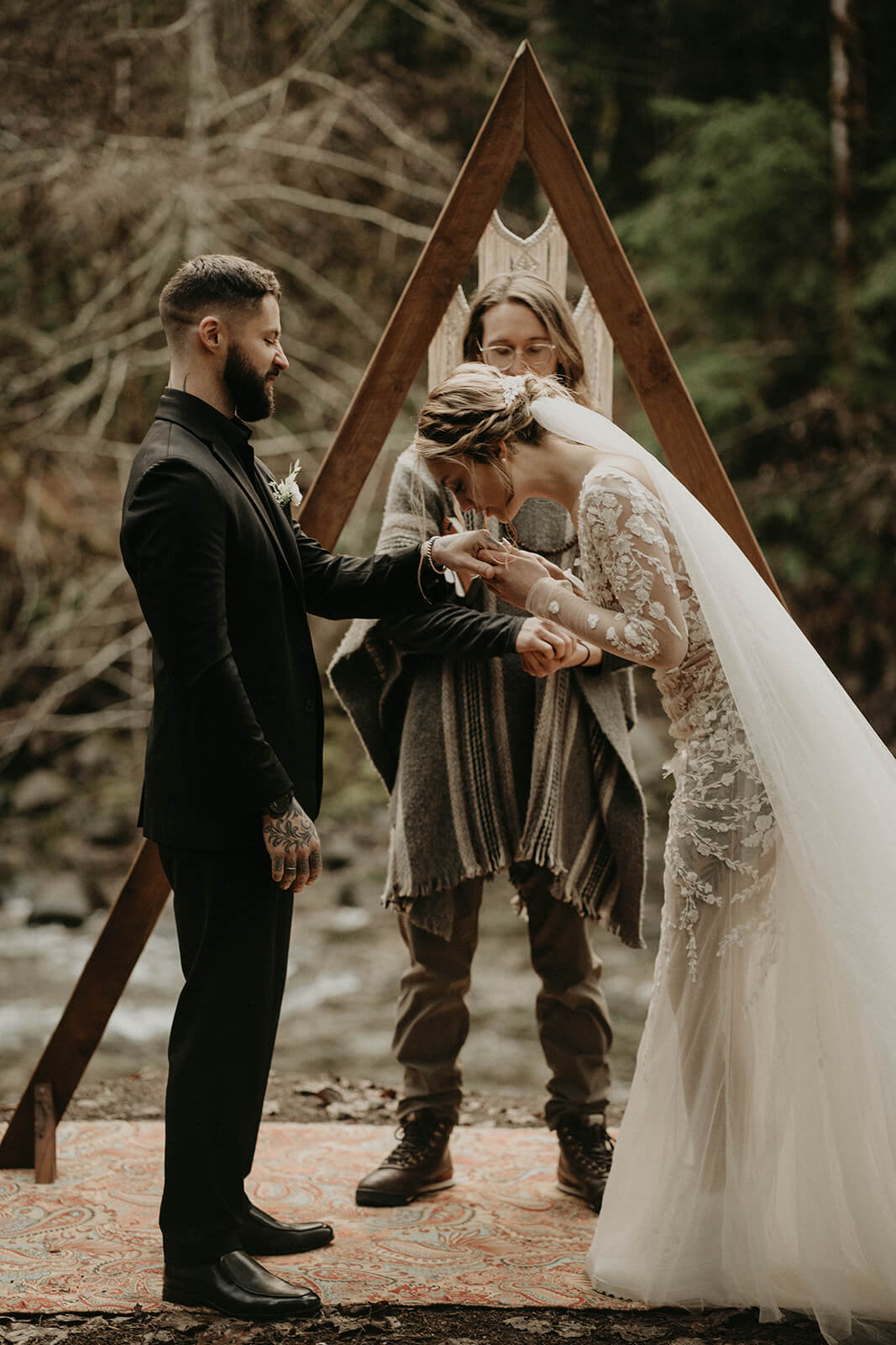 Bride kissing groom's hand during elopement ceremony