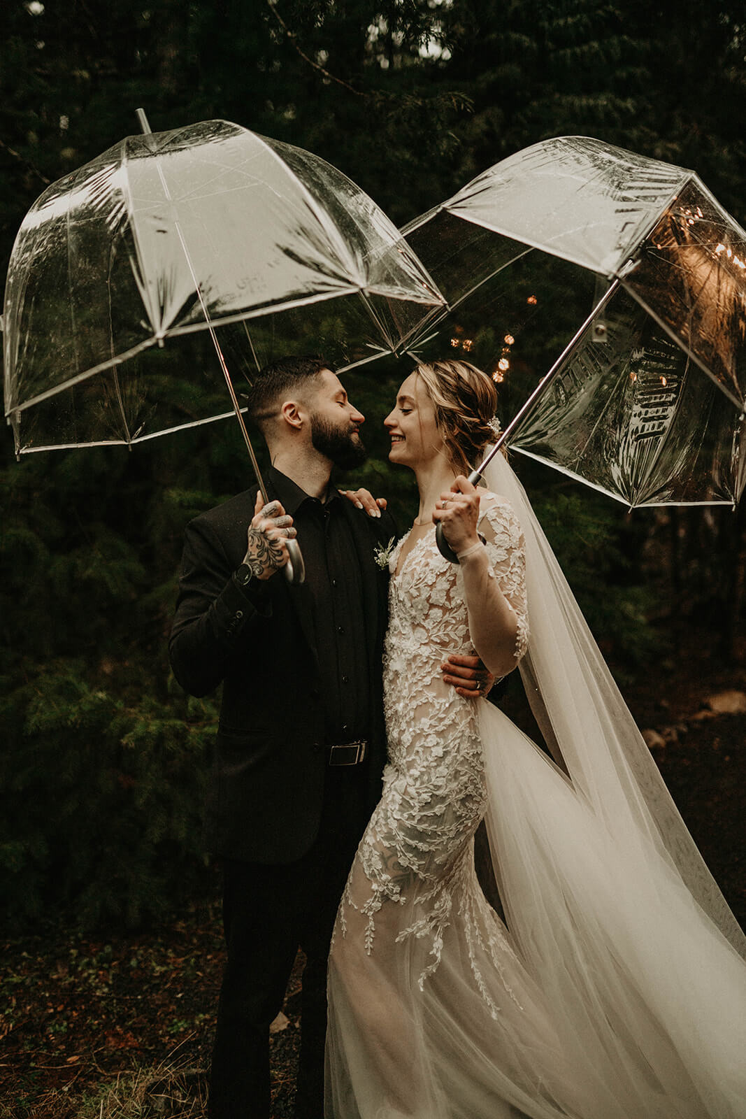 Bride and groom holding clear umbrellas at Mount Rainier elopement