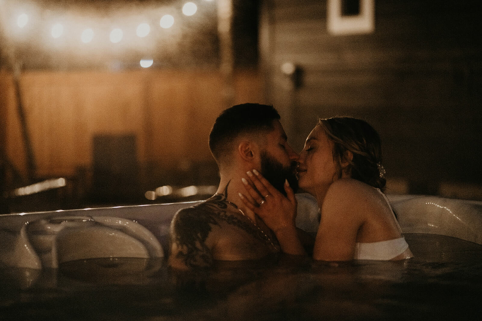 Bride and groom kissing in the hot tub at cozy cabin in Mount Rainier