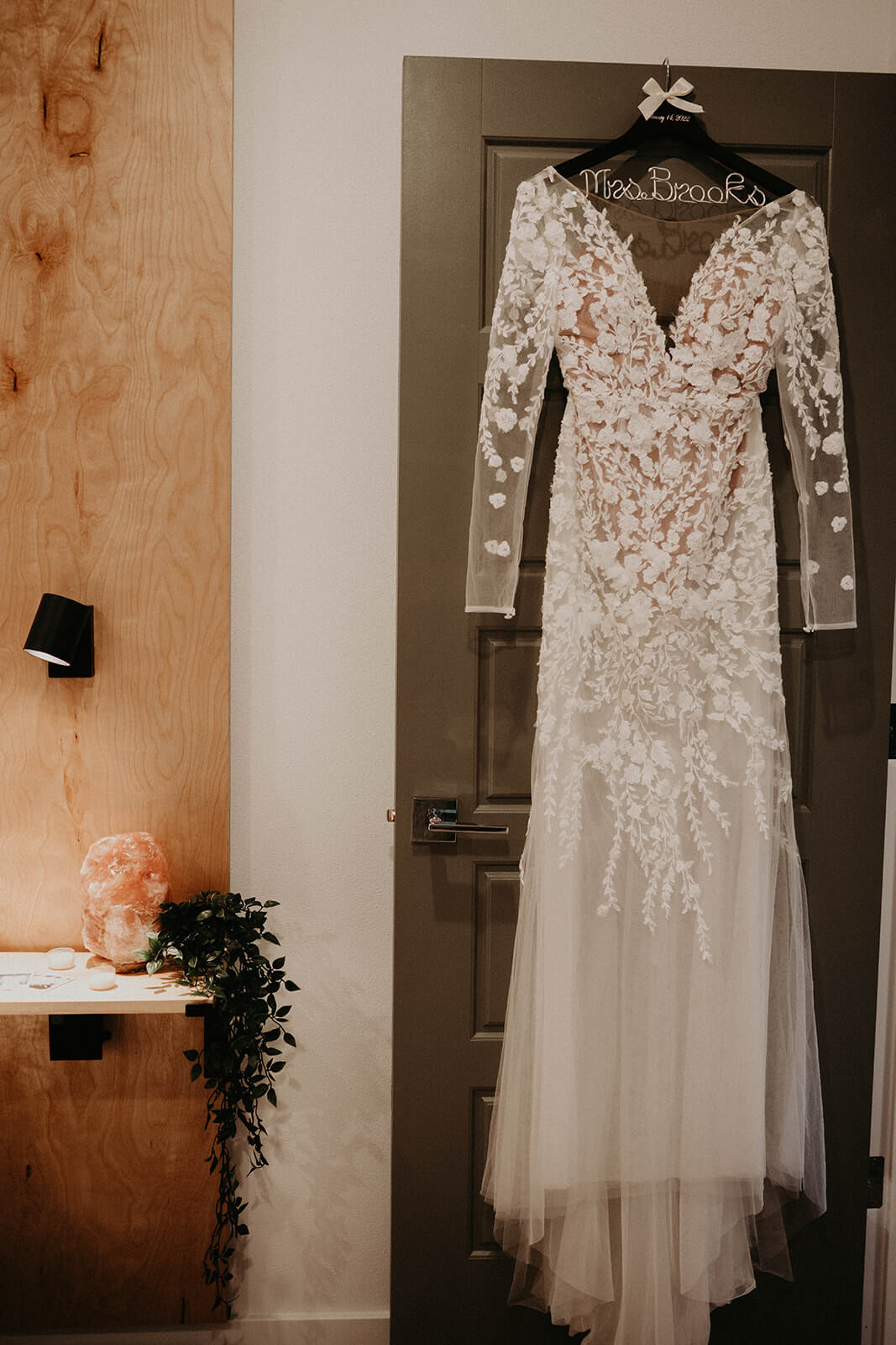Lace wedding dress hanging on wood door