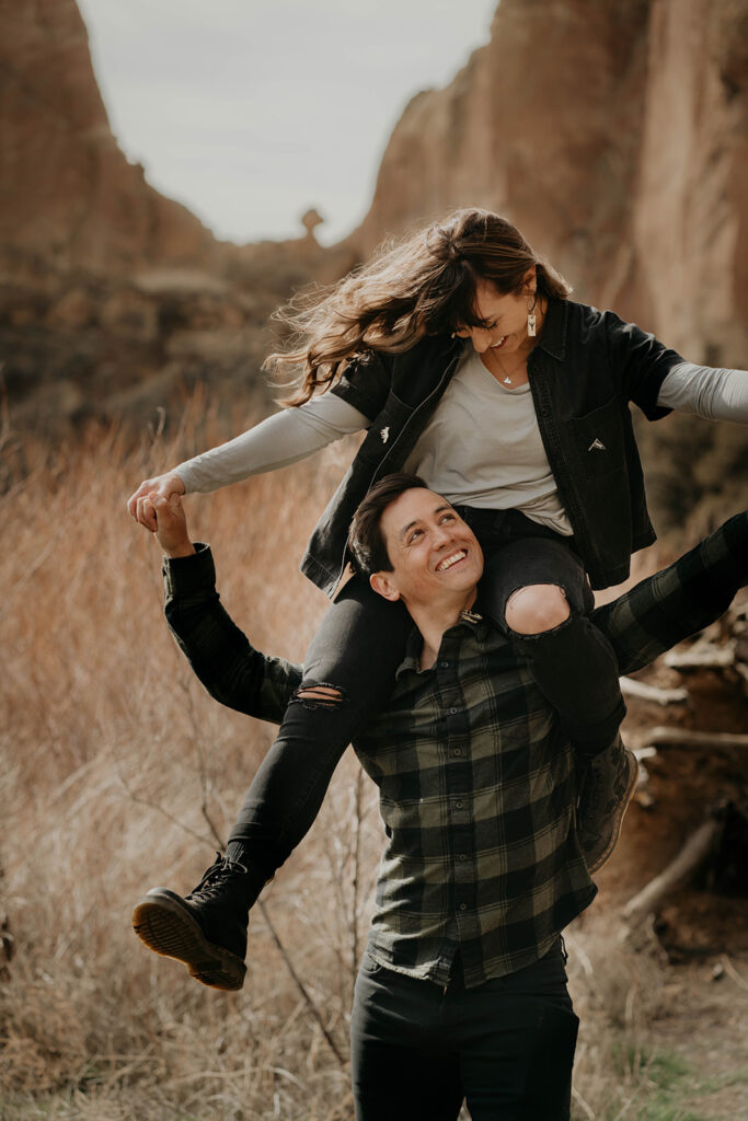 Woman sitting on man's shoulders during engagement photography session