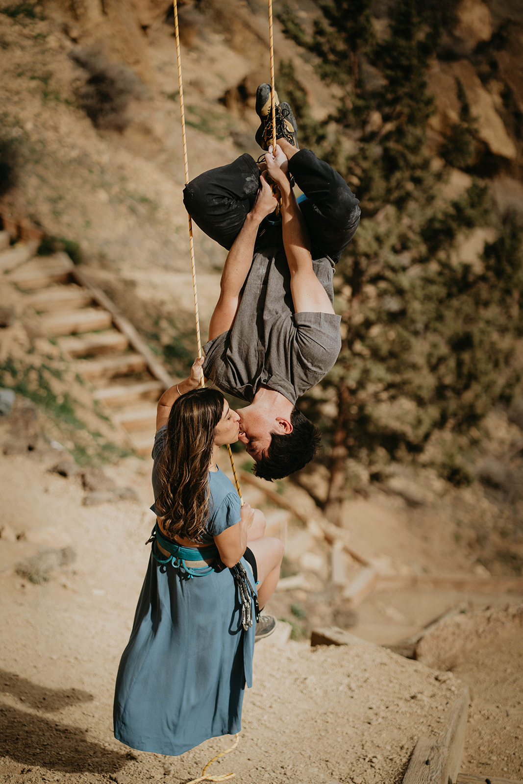 Couple kissing while rock climbing at Smith Rock for engagement session