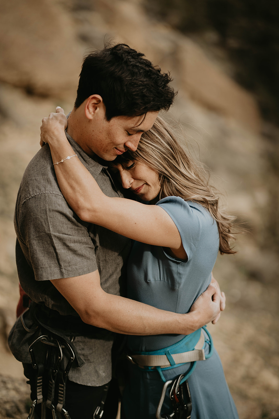 Couple hugging while rock climbing at Smith Rock for engagement session