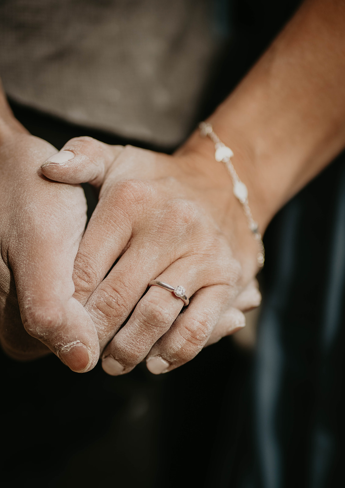 Couple holding hands during rock climbing engagement session
