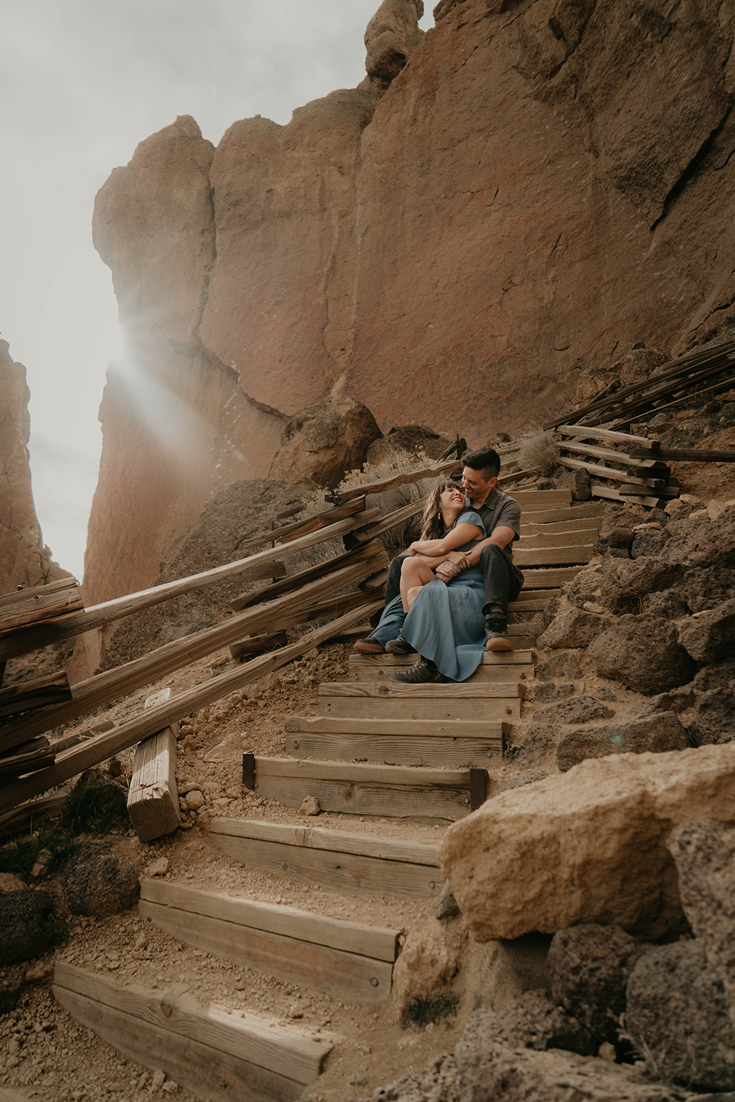 Couple sitting on the steps after rock climbing engagement session at Smith Rock