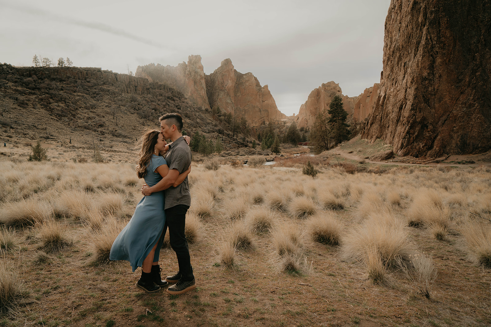 Couple hugging during rocking climbing engagement session at Smith Rock