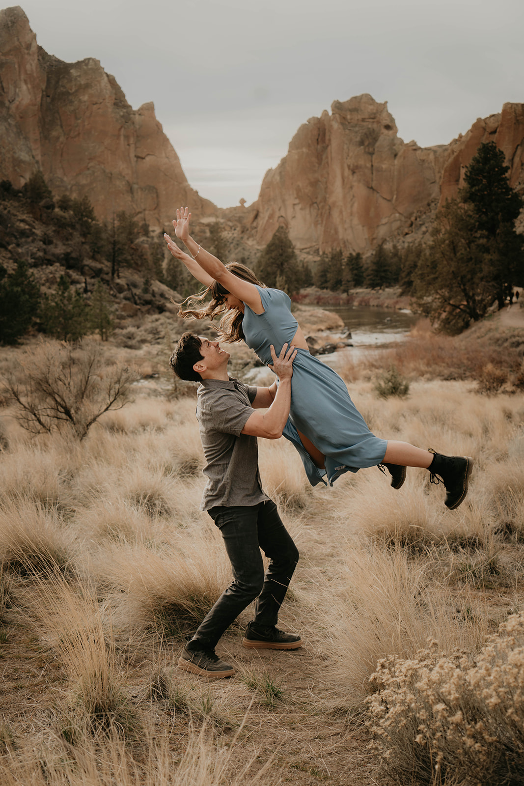 Man lifting woman up into the air at Smith Rock State Park