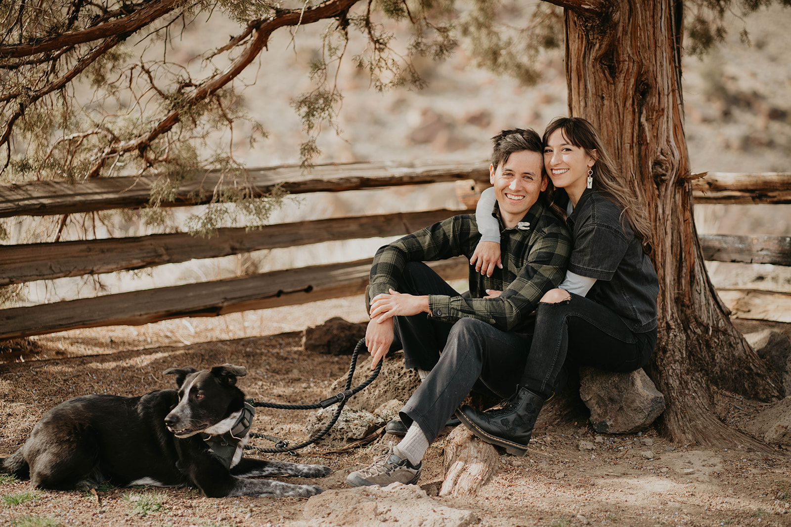 Couple sitting and hugging at rock climbing engagement session