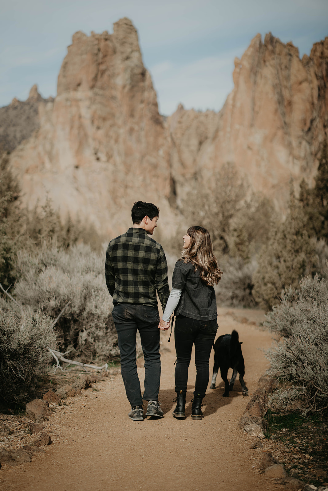 Couple holding hands while walking along a trail at Smith Rock