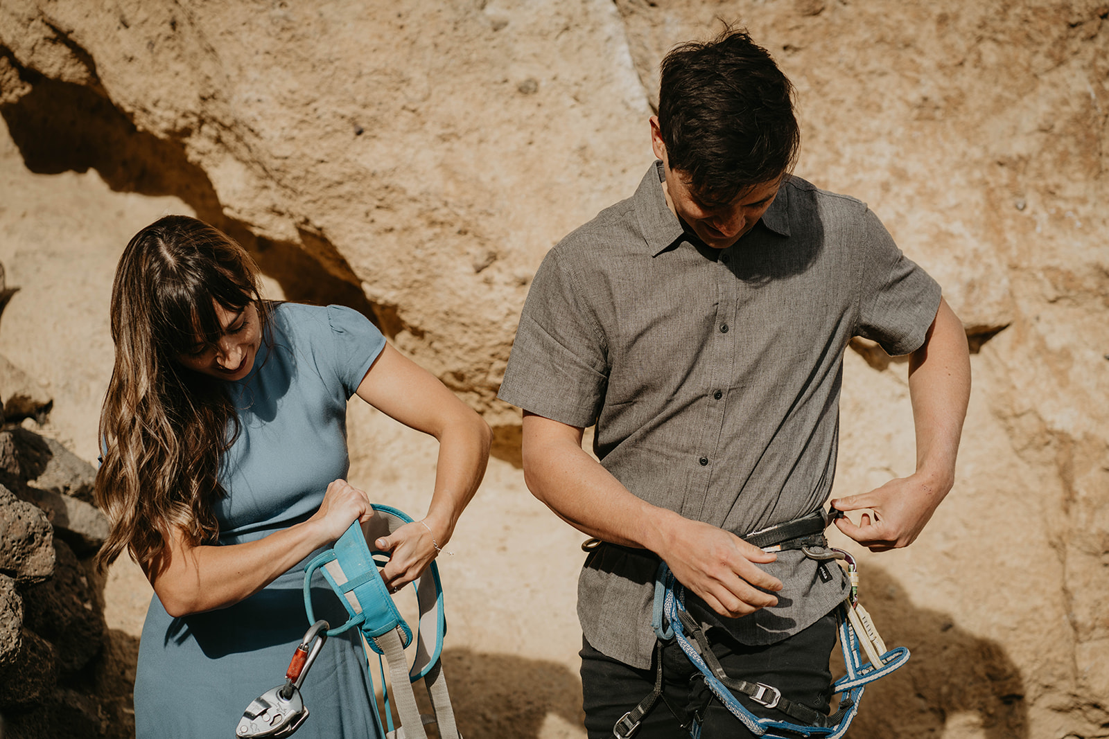 Couple putting on rock climbing gear for engagement session