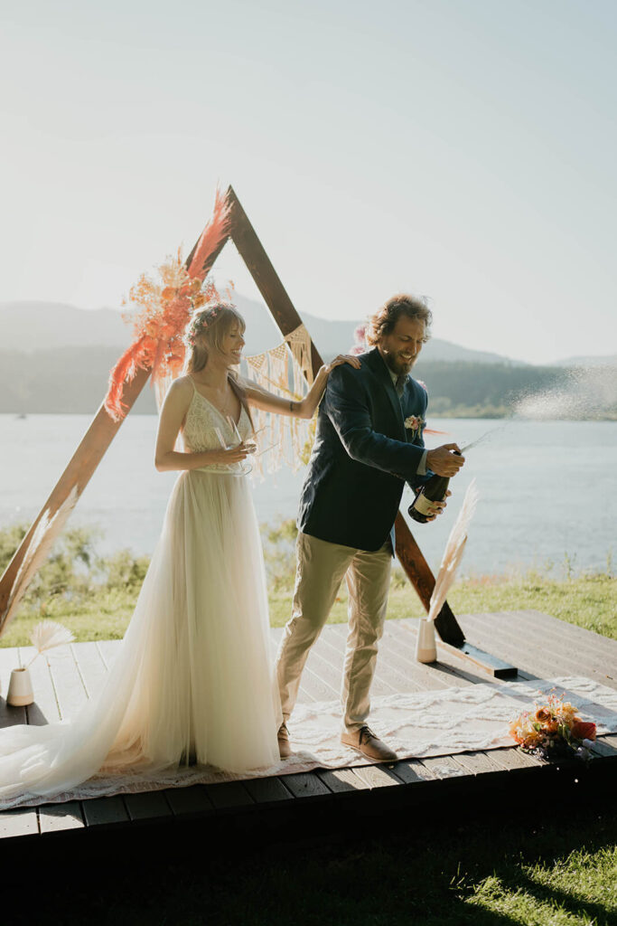 Bride and groom pop champagne after styled shoot wedding ceremony