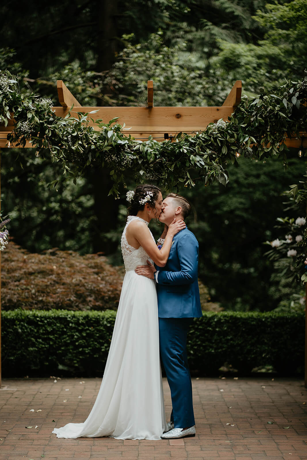 Two brides kissing at Leach Botanical Garden wedding altar