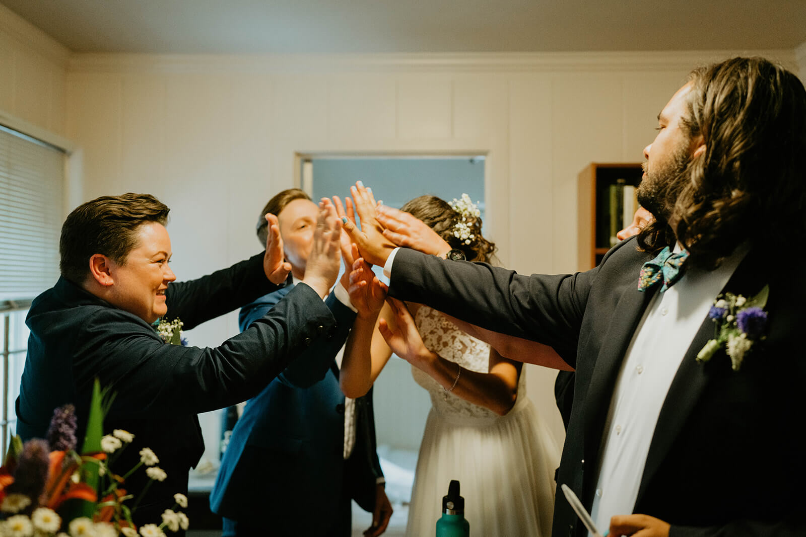 Two brides cheering with friends after wedding ceremony