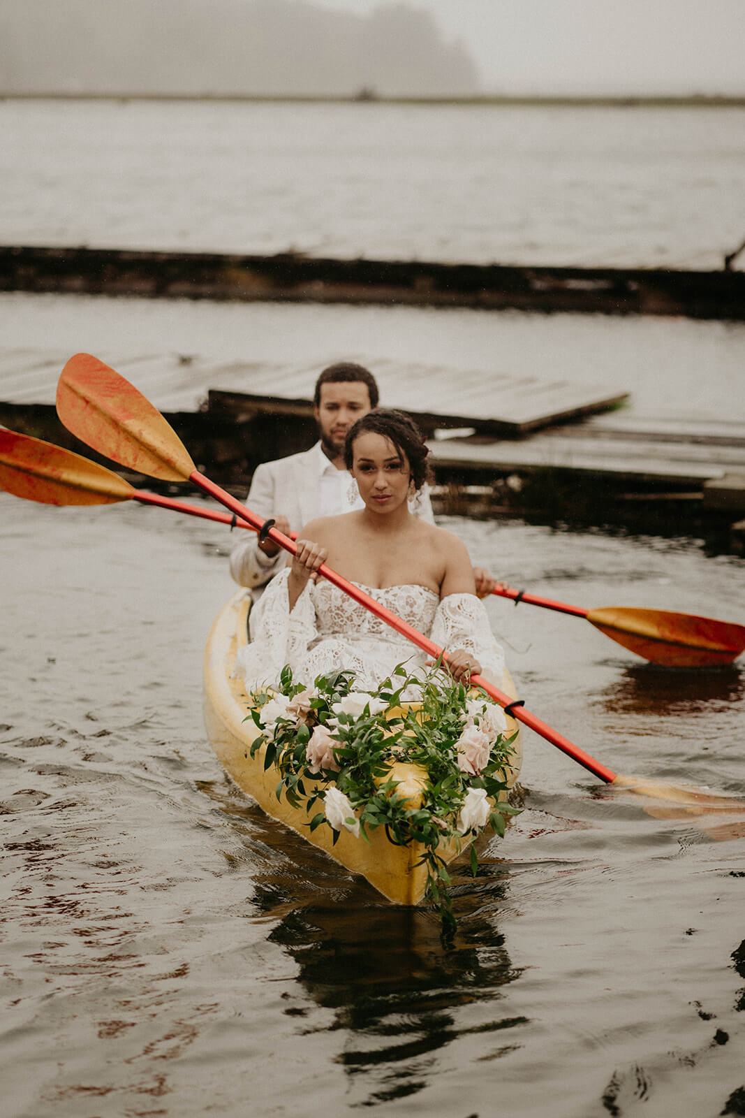 Bride and groom paddling in canoe during Oregon Coast elopement